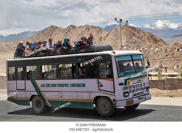 Ladakhis travel on an overloaded bus in Choglamsar, Ladakh, Jammu and Kashmir, India. - CHOGLAMSAR, LADAKH, INDIA, 08/07/2014