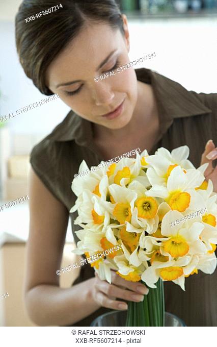 young woman preparing¬† flowers