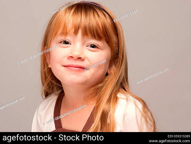 Portrait of an Adorable Red Haired Girl on a Grey Background