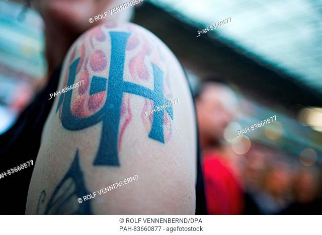 A female fan of the band 'Unheilig' presents her tattoo with the logo of the band at RheinEnergieStadion in Cologne, Germany, 10 September 2016