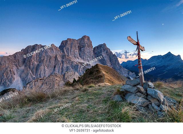 Europe, Italy, Veneto, Cadore. The summit cross on the Col de la Puina at sunset with mount Pelmo in the background, Dolomites