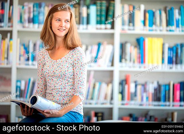 Cute female university/highschool student with books in library