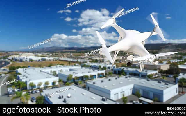 Unmanned aircraft system (UAV) quadcopter drone in the air over commercial buildings