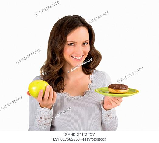 Young Happy Woman Holding Green Apple And Donut In Front Of Fridge