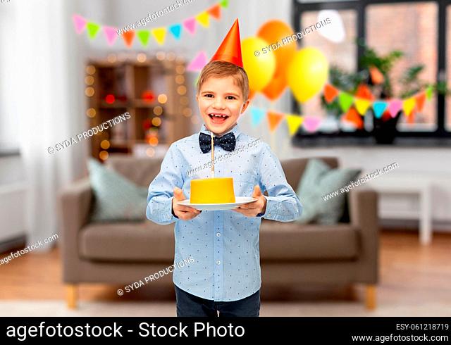 smiling boy in party hat with birthday cake