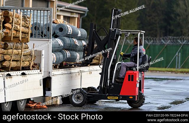 20 January 2022, Lower Saxony, Bad Fallingbostel: Wire fence against the spread of African swine fever (ASF) is driven into a hall with a forklift truck