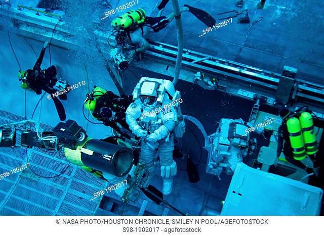 NASA astronauts Rex Walheim, left, and Mike Fossum arei aided by divers as they work in a mock up of the space shuttle's payload bay as the crew of STS-135...