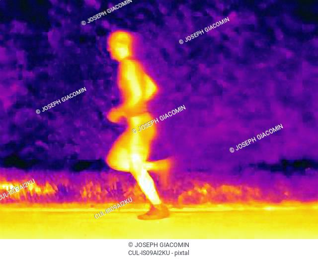 Side view thermal photograph of young male athlete running. The image shows the heat of the muscles