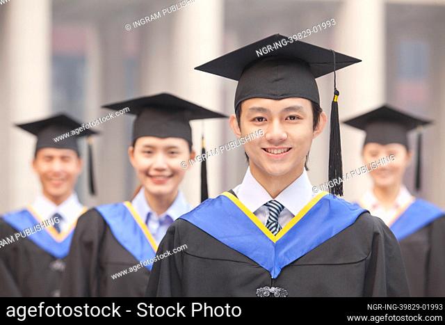 Four University Graduates Smiling, Looking at Camera