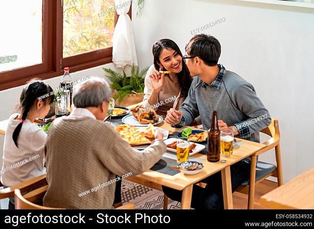 Happy asian multigenerational family of dad mom daughter girl and grandfather eating lunch together at home. Happy family engagement togetherness concept