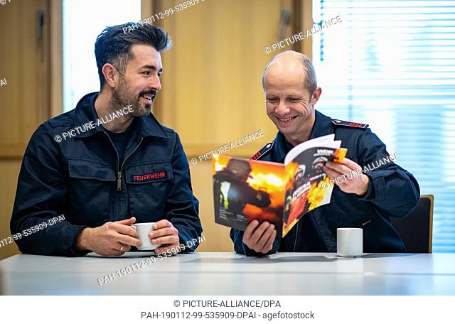 10 January 2019, North Rhine-Westphalia, Gelsenkirchen: The firemen Philip (l) and Hacki sit in the lounge of the fire station in Gelsenkirchen and browse...