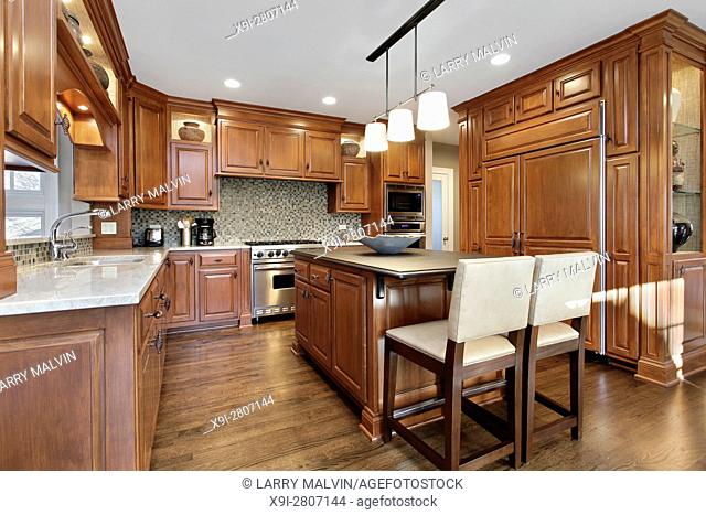 Kitchen in luxury home with oak wood cabinetry and center island. Northern Suburbs of Chicago, IL. USA