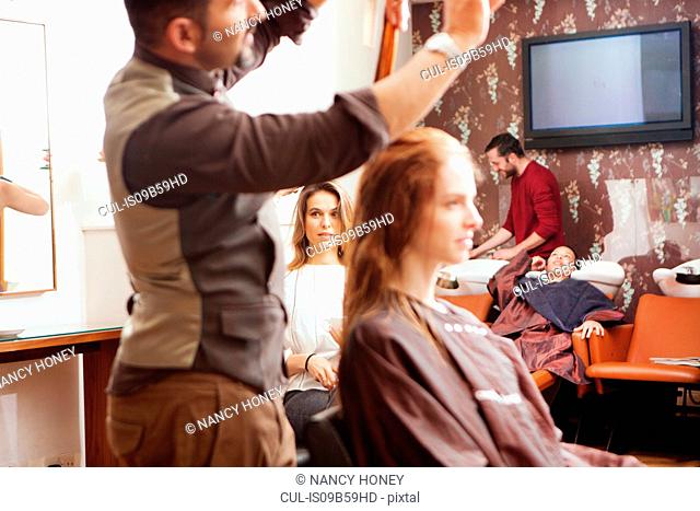 Female customers having their hair styled in hair salon