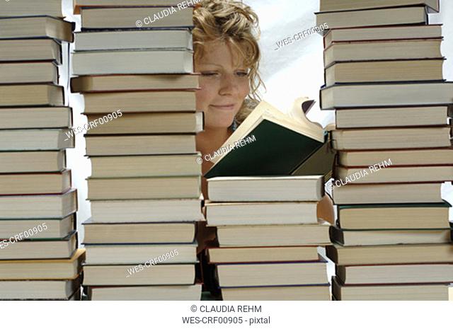 Woman with pile of books, smiling
