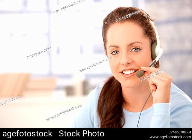 Portrait of young, attractive dispather talking on headphones, smiling