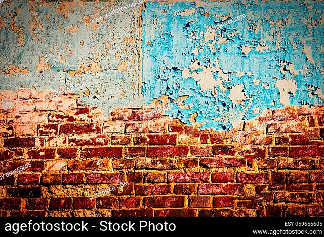 Home renovation. Half painted red brick wall with peeling blue worn paint, abandoned house. Frame for text
