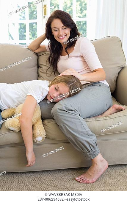 Mother looking at daughter sleeping on her lap