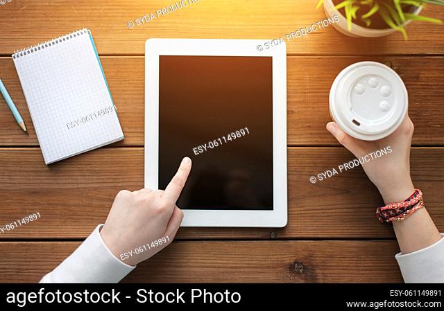 close up of woman with tablet pc on wooden table
