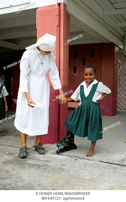Girl wearing single inline skate together with a nun at an Ursuline convent and orphanage in Georgetown, Guyana, South America