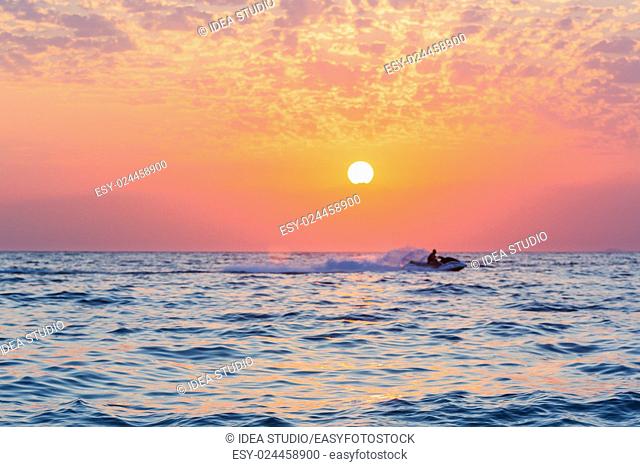 Colorful sunset over the sea with beautiful sky and jet ski silhouette, Abkhazia, Black sea