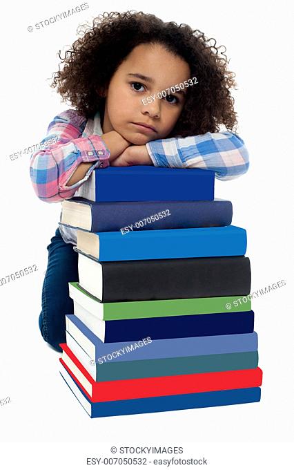 Little girl getting bored after reading set of books. Blank face expression
