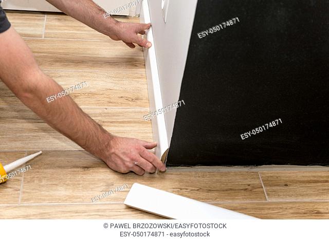 Close up of man fitting skirting board