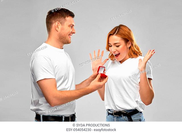 man giving woman engagement ring on valentines day