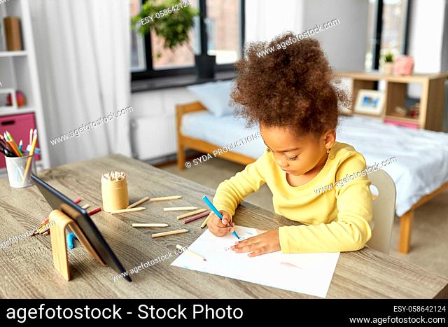 little girl drawing with coloring pencils at home