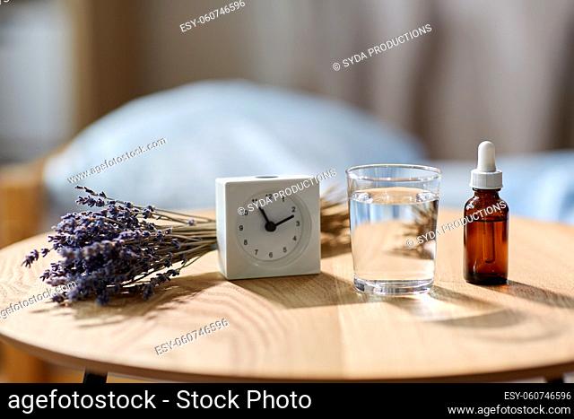 alarm clock, lavender oil and glass of water