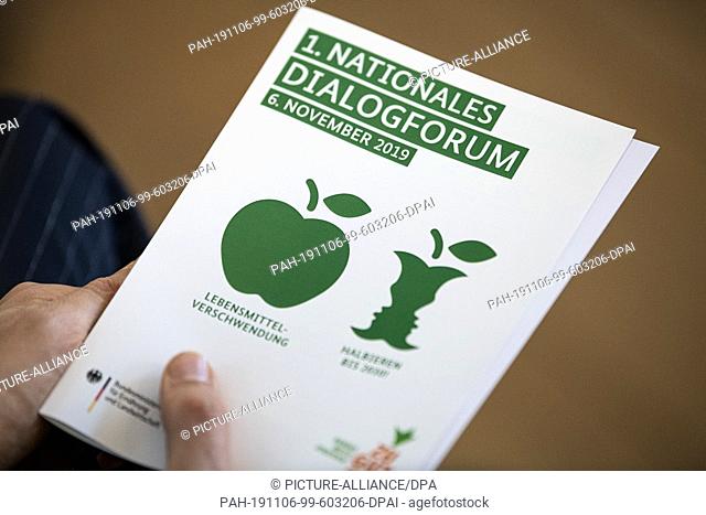 06 November 2019, Berlin: At a press conference, a woman is holding a leaflet from the National Dialogue Forum on Food Waste