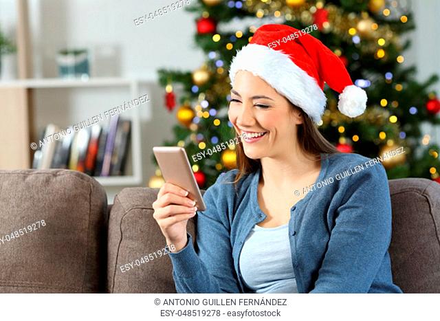 Girl reading phone messages in christmas at home