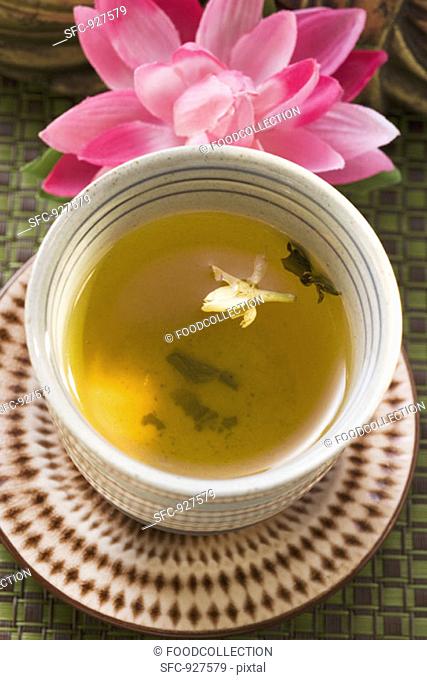 Jasmine tea in small bowl in front of water lily