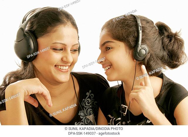 Maharashtrian and Gujarati teenage and eleven year old girls listening to music using earphone MR686M;191