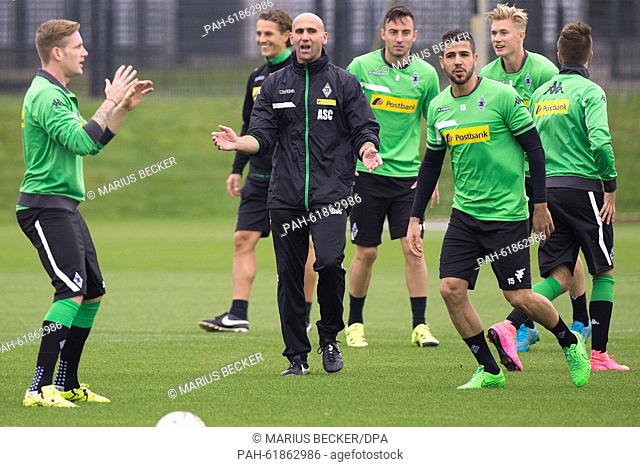 Moenchengladbach's caretaker coach Andre Schubert (3-L) instructs his players during a training session of German Bundesliga soccer club Borussia...