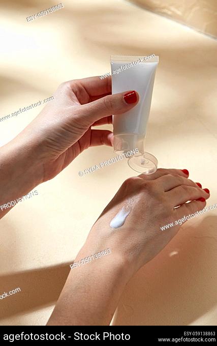 female hands applying moisturizer to skin