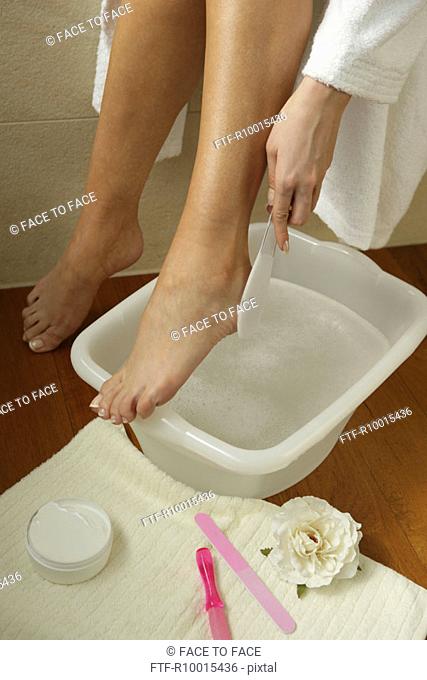 A high angle view of the leg of a woman above a soapy tub