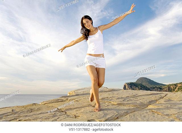 Brunette palyful woman in a cliff in Ibiza, Balearic Islands