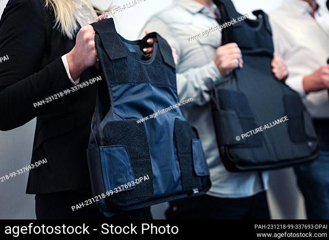 18 December 2023, North Rhine-Westphalia, Cologne: Bailiffs hold their new protective vests in their hands during a press event