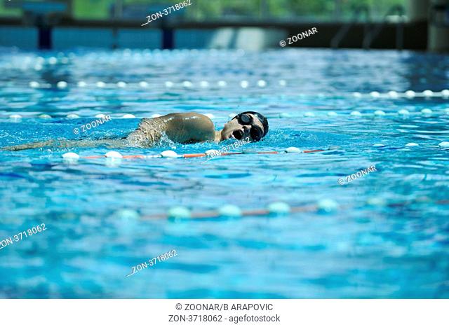 young healthy with muscular body man swim on swimming pool and representing healthy and recreation concept