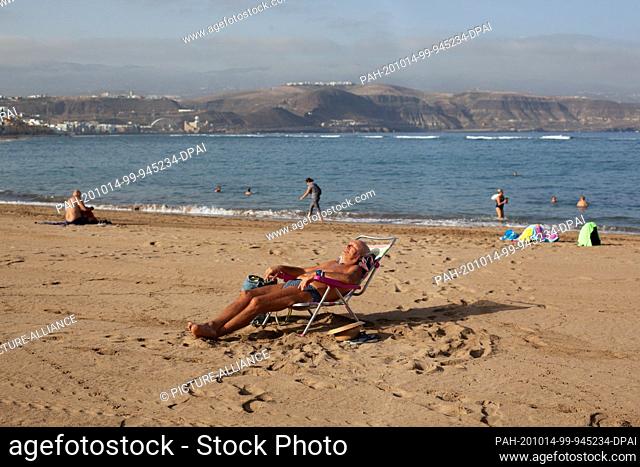 14 October 2020, Spain, Gran Canaria: A man is sunbathing on the beach of Las Canteras in Gran Canaria. The Canary Islands have the lowest number of new...