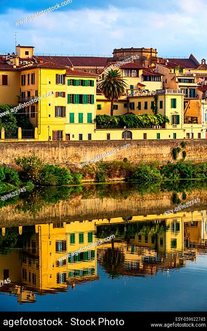 City street view with houses and reflection in Arno river, Florence, Italy
