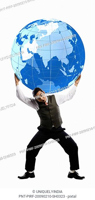 Businessman balancing a globe over his shoulders