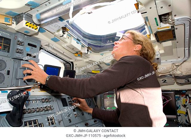 Canadian Space Agency astronaut Julie Payette, STS-127 mission specialist, looks through an overhead window while operating controls on the aft flight deck of...