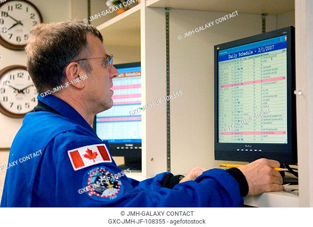 Canadian Space Agency astronaut Dafydd R. (Dave) Williams, STS-118 mission specialist, uses a computer to check his daily schedule in the check-out facility at...