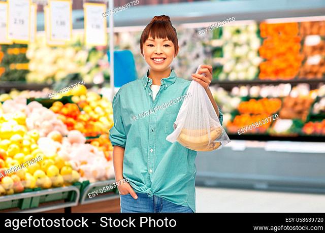 happy woman with bananas in reusable net bag