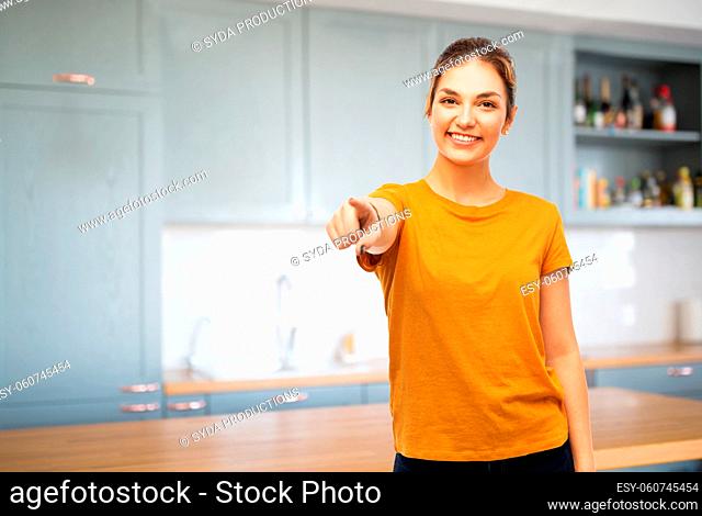happy woman pointing finger to camera at kitchen