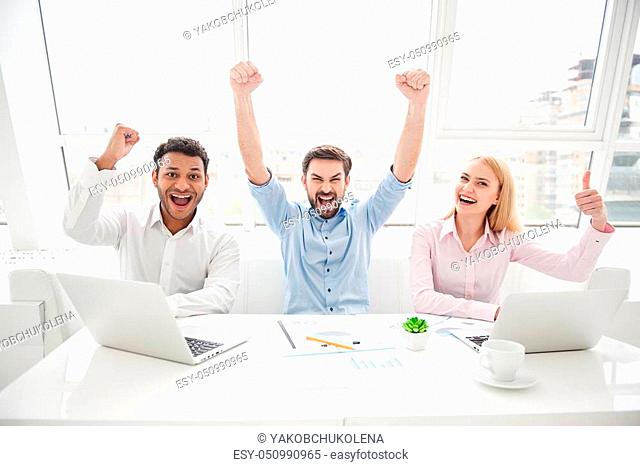 Count on us. Shot of group of colleagues feeling overjoyed sitting at desk in their modern office