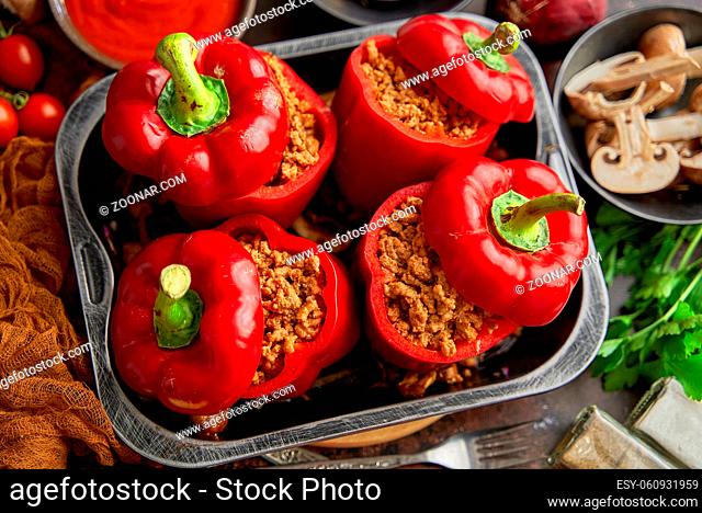 Sweet red peppers stuffed with meat and tomato in a vintage frying tray. Top view, flat lay