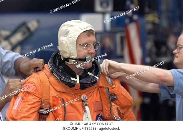 Astronaut Andrew S. W. Thomas, STS-114 mission specialist, dons a training version of the shuttle launch and entry suit, prior to the start of a mission...