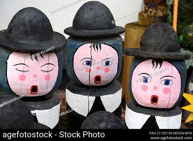 05 December 2021, Saxony, Borsdorf: Caroling figures, on which Denny Pfaff and his son Felix have repaired parts of the chipped paint